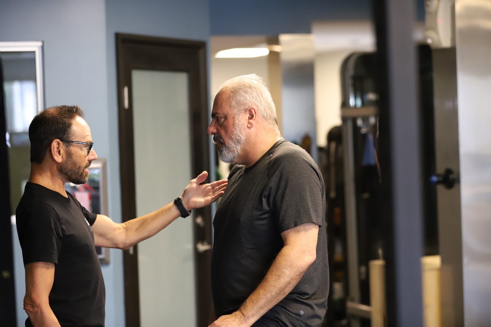 Coach in close conversation with an older client working through controlled progressions